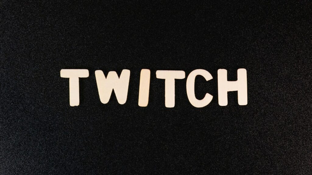 Holzbuchstaben formen das Wort Twitch auf schwarzem Hintergrund